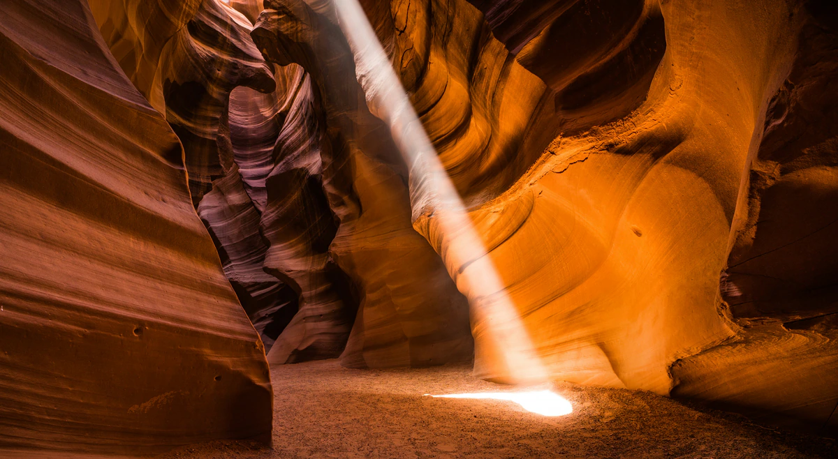 Sunbeam reaching the sandy floor inside Antelope Canyon