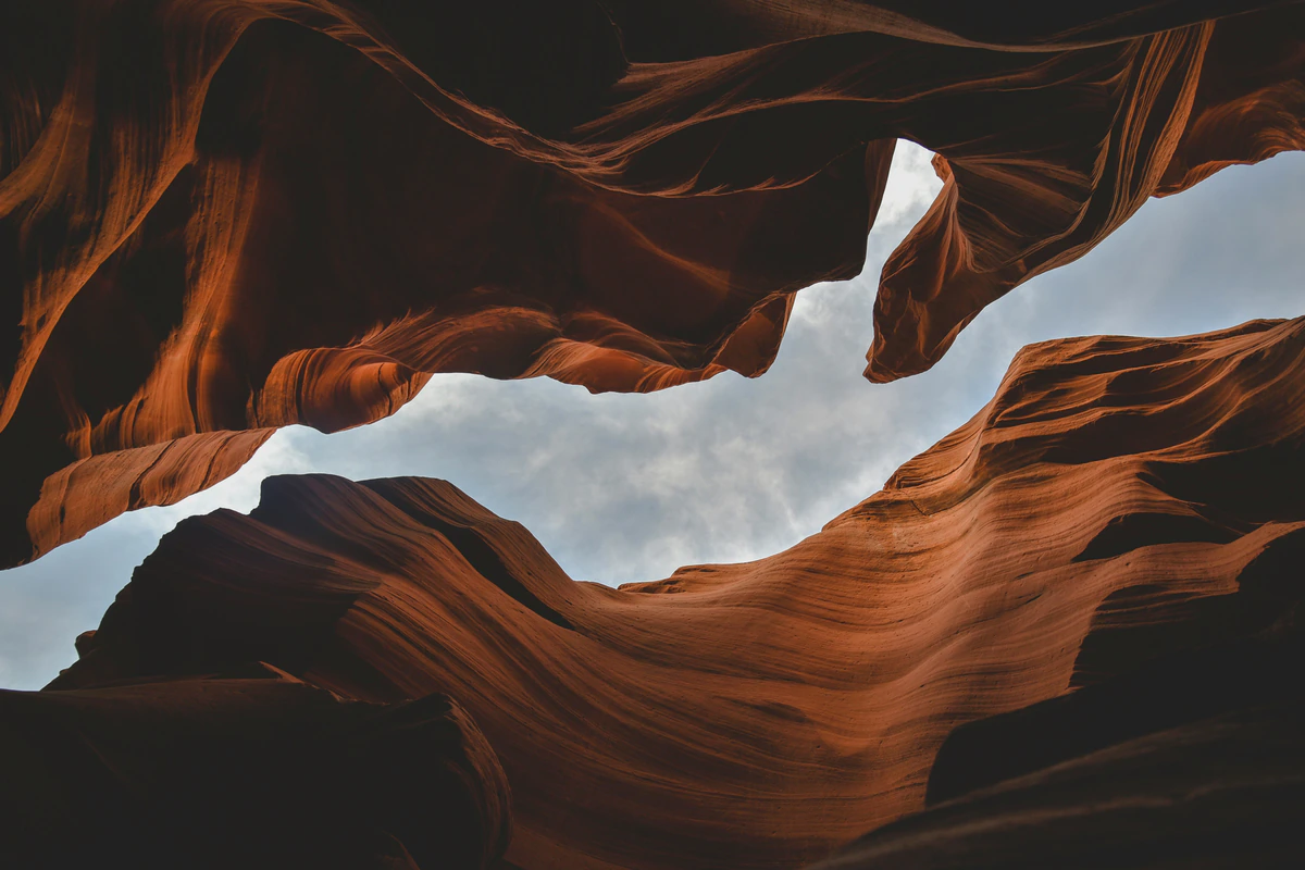 Cloudy sky framed by dark sandstone walls in Antelope Canyon