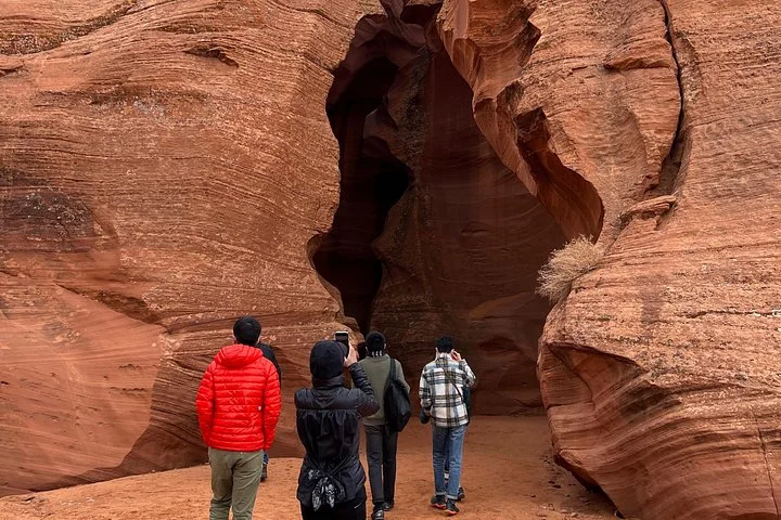 Small tour group at the entrance to an Antelope Canyon slot